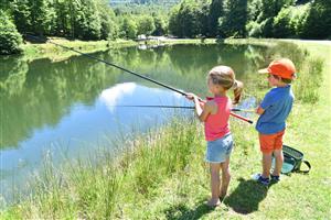 boy and girl fishing in pond